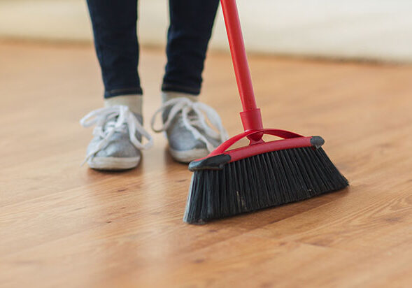 Lady sweeping Laminate floor | Kay Riley Flooring and Design